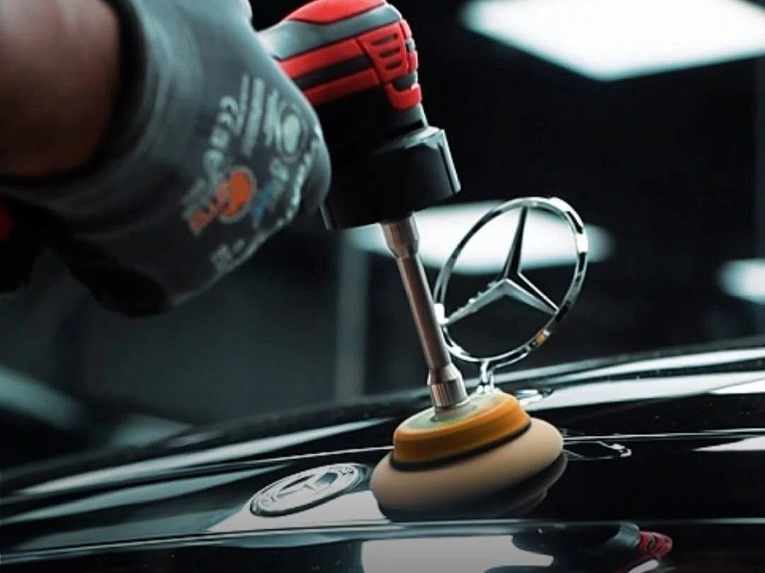 RestorFX technician performing precision clearcoat work around a Mercedes-Benz emblem